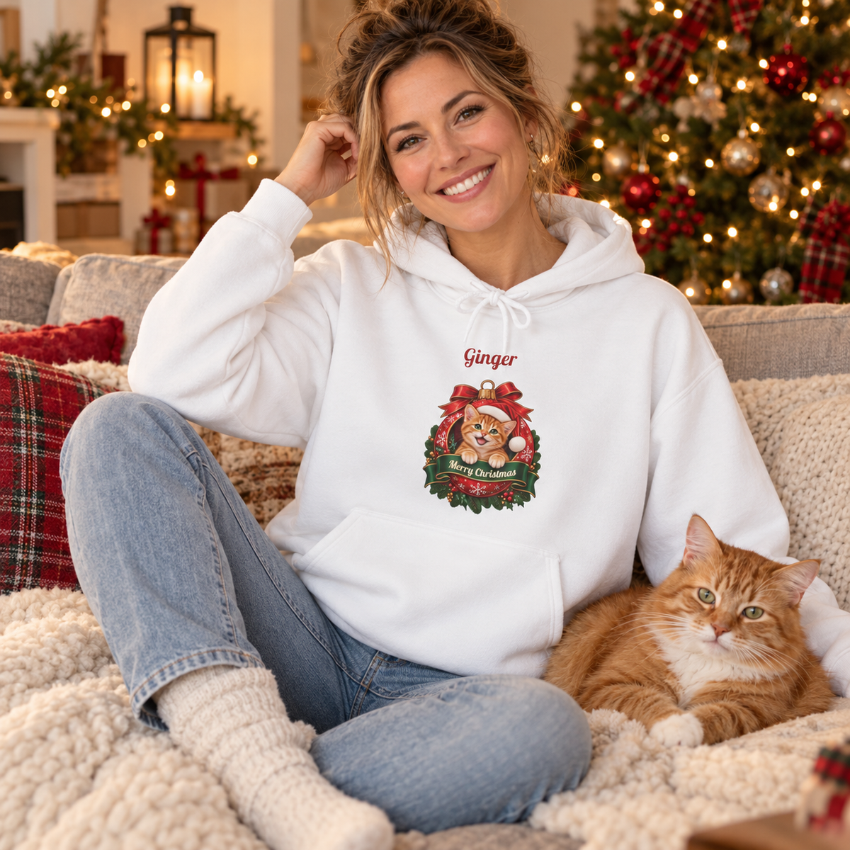 Woman wearing the White Personalized Orange Tabby Cat Christmas Hoodie on the sofa with her ginger cat