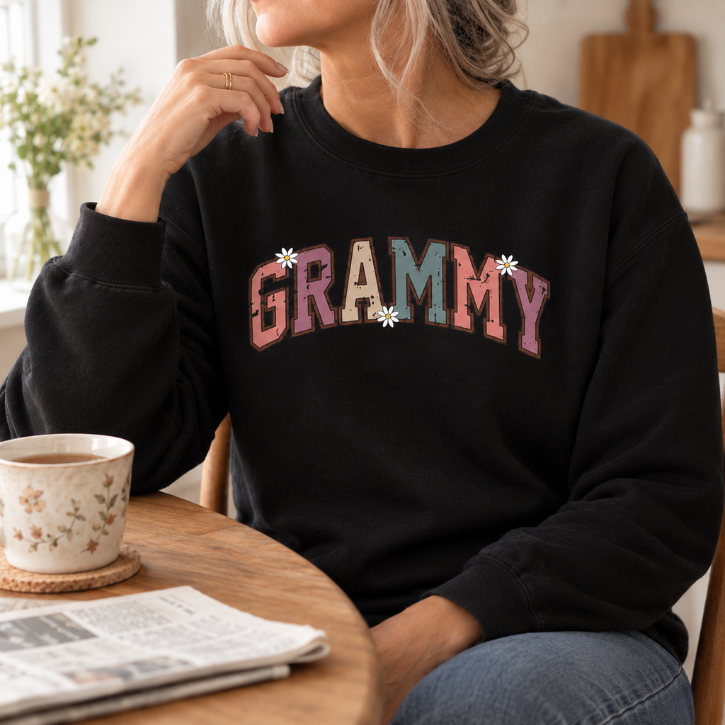 Woman wearing the black Grammy Retro Daisy Sweatshirt at a kitchen table
