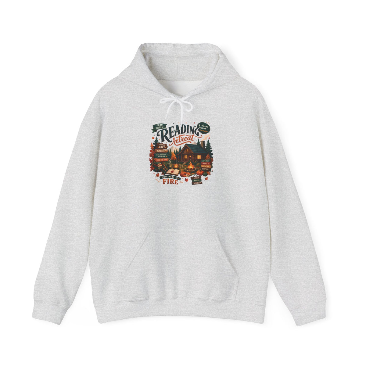 Ash Cozy Cabin Reading Retreat hoodie with a glowing log cabin in the pines, stacks of books and a crackling fire, front view