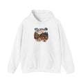 White Cozy Cabin Reading Retreat hoodie with a glowing log cabin in the pines, stacks of books and a crackling fire, front view