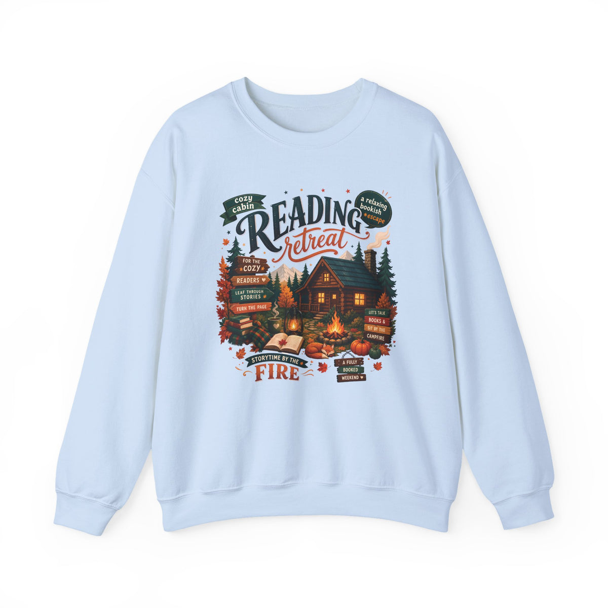 Light Blue Cozy Cabin Reading Retreat sweatshirt with a glowing log cabin in the pines, stacks of books and a crackling fire, front view