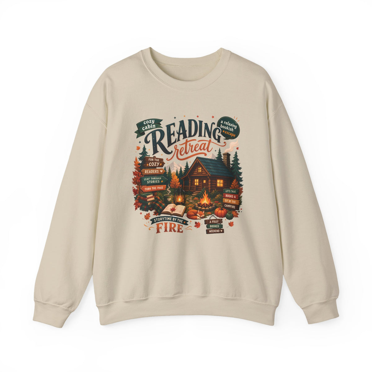 Sand Cozy Cabin Reading Retreat sweatshirt with a glowing log cabin in the pines, stacks of books and a crackling fire, front view
