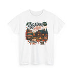 White Cozy Cabin Reading Retreat t-shirt with a glowing log cabin in the pines, stacks of books and a crackling fire, front view