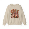 Sand Cozy Season sweatshirt with cable-knit lettering, hot cocoa, a candle and a plaid blanket, front view