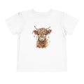 White Highland Cow With Christmas Lights toddler t-shirt with a watercolor highland cow wearing colorful Christmas lights, front view
