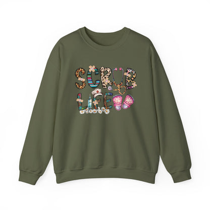 Military green Scrub Life nurse sweatshirt with patterned lettering, stethoscope and clogs