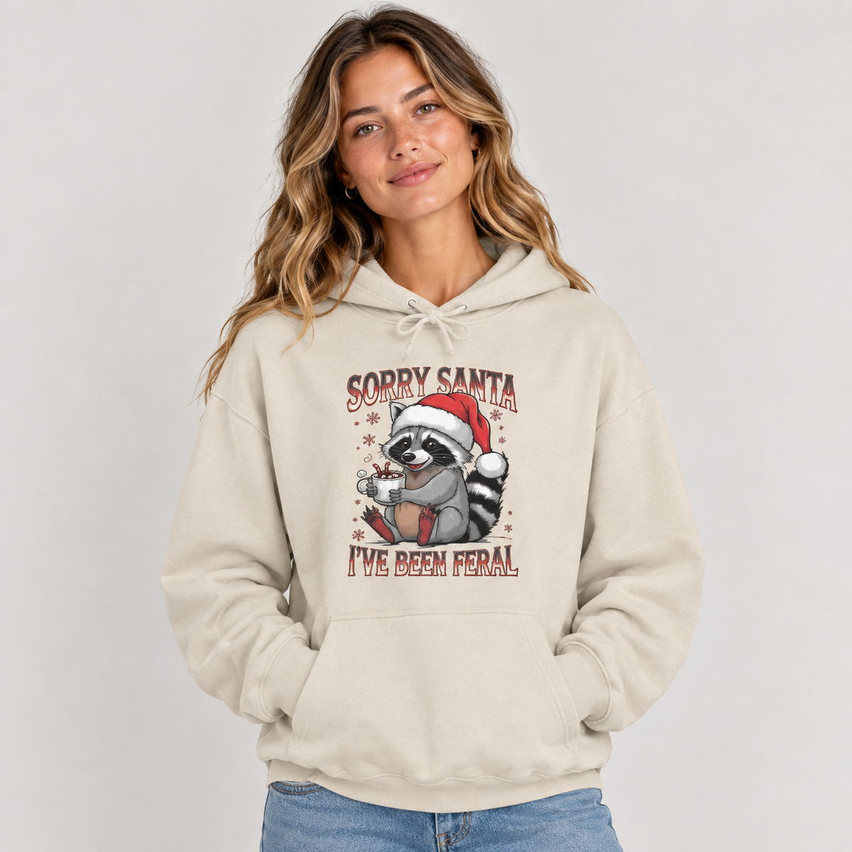 Woman wearing the Sand Sorry Santa I've Been Feral Raccoon Hoodie with jeans