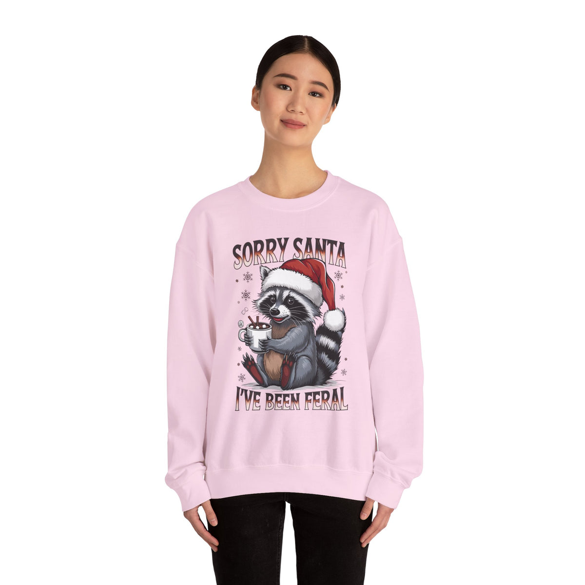 Woman wearing the Light Pink Sorry Santa I've Been Feral Raccoon Sweatshirt