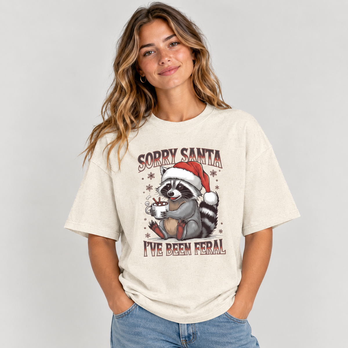 Woman wearing the Natural Sorry Santa I've Been Feral Raccoon T-Shirt with jeans